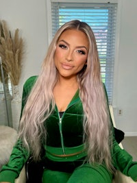 a woman in a green velour tracksuit posing for a photo